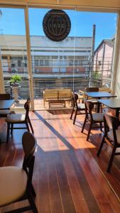 a restaurant with tables and chairs and a large window at IHOC - Phuket OldTown in Ban Lo Long