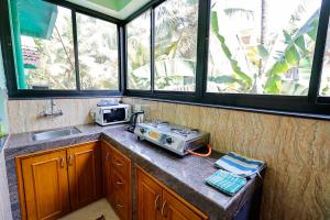 a kitchen with a counter with a toaster and a microwave at Caphina Coastal Comforts in Benaulim