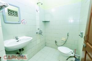a bathroom with a sink and a toilet at Caphina Coastal Comforts in Benaulim +20 photos