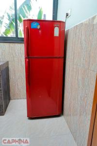 a red refrigerator in the corner of a room at Caphina Coastal Comforts in Benaulim