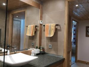 ein Badezimmer mit Waschbecken, Toilette und Spiegel in der Unterkunft Appartement luxueux 3 pièces, spa privé, skis aux pieds - FR-1-810-21 in Les Saisies