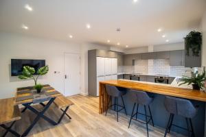 an open kitchen with a bar and stools at 29 Twyford in Eastleigh