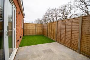 a backyard with a wooden fence and a green lawn at 29 Twyford in Eastleigh