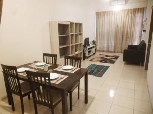 a dining room table and chairs in a living room at Setia Homestay Chemor Setia in Chemor