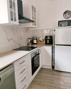 Una cocina con electrodomésticos blancos y un refrigerador blanco. en Oohlala - High ceiling Peaceful Relaxing Bushland view, en Mount Tamborine