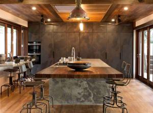 a kitchen with a large wooden island with bar stools at Spice At Oak Absolute Beachfront with Private Pool Near Port Douglas in Oak Beach