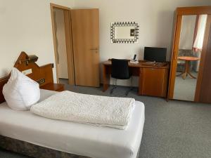 Un dormitorio con una cama y un escritorio con una computadora. en Gästezimmer Gasthof Becker, en Wülfrath