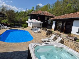 a swimming pool in a yard with chairs and a house at АРНАТА КЪЩА in Yakovtsi