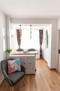 ein Wohnzimmer mit einem Stuhl und einem Bett in der Unterkunft Ten House in Piteşti