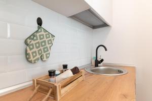 eine Küche mit einem Waschbecken und einem Holztisch in der Unterkunft Ten House in Piteşti + 15 Fotos