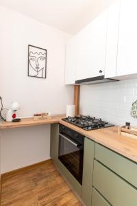 eine Küche mit weißen Schränken und einem Herd mit Backofen in der Unterkunft Ten House in Piteşti