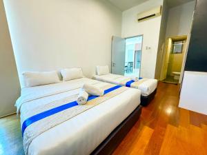 Un dormitorio con dos camas con toallas encima. en Sunset Seaview Vacation Condos @ IMAGO Shopping Mall, en Kota Kinabalu