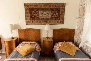 1 dormitorio con 2 camas y una alfombra en la pared en Pikisaari Apartment, en Oulu