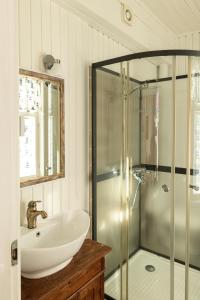 Un baño con ducha de cristal y lavabo. en Pikisaari Apartment, en Oulu