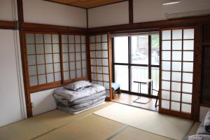 a room with a bed in a room with windows at Hotel Relation in 門司港 in Kitakyushu