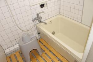 a bathroom with a toilet next to a tub at Hotel Relation in 門司港 in Kitakyushu +32 photos