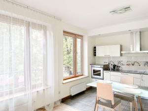a kitchen with white cabinets and a table and chairs at Elite centre, free parking, ultra-desirable 1 of 1, lux view in Rīga