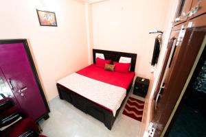 Cette petite chambre comprend un lit avec des draps rouges. dans l'établissement Krishna Kunj Homestay & Resort Ayodhya, à Faizābād 29 autres photos