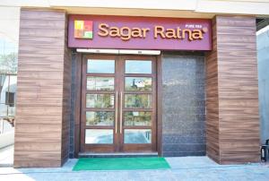 a restaurant with a large door on a building at Hotel President in Bharwain