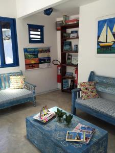 uma sala de estar com dois sofás azuis e uma mesa em Pousada Barbara em Pipa
