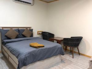 a bedroom with a bed with two chairs and a table at Rashuthere Maldives in Rasdu +111 photos