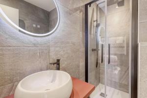 Un baño con lavabo blanco y ducha en Anglade Hotel, en Le Lavandou