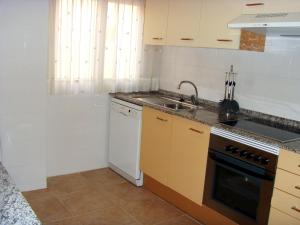 a kitchen with a sink and a stove top oven at Beachfront penthouse in Residencial Dos Mares in La Manga del Mar Menor