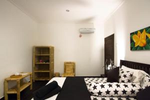 a bedroom with a black and white bed and a shelf at Black & White Cottages in Gili Trawangan