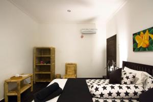 una camera con letto bianco e nero e mensola di Black & White Cottages a Gili Trawangan