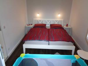 a bedroom with a bed with red sheets and red pillows at Ferienwohnung Am Recknitzhang in Carlewitz