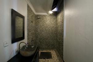 un bagno con lavandino e doccia di Black & White Cottages a Gili Trawangan Altre 13 foto