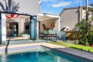 a house with a swimming pool in front of a house at Colourwave Terrace - A Technicolor Poolside Stay in Newcastle
