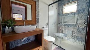 um banheiro com vaso sanitário, pia e chuveiro em Pouso Flor da serra em Tiradentes mais 37 fotografias