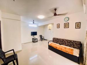 a living room with a couch and a clock on the wall at 2 BHK Luxury Apartment in Thivim Goa in Tivim