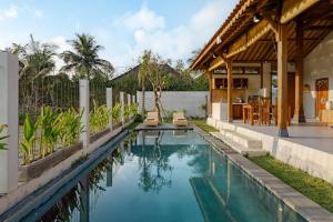 a swimming pool in the backyard of a house at Pucuk Ubud Villa in Ubud