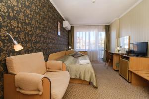 a hotel room with a bed and a couch and a television at Noviz Hotel in Plovdiv