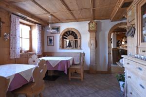 a dining room with a table and chairs and a clock at Agriturismo Soleseid in San Vigilio Di Marebbe