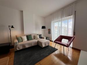 a living room with a couch and a chair at Apartamento do Atlântico in Ponta Delgada