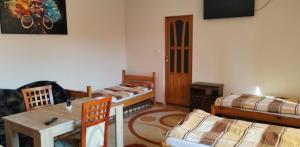a living room with two beds and a table at Vendégváró szálláshely Sajószentpéteren in Sajószentpéter