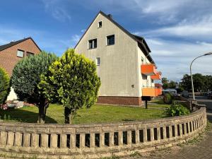 una casa con una valla y árboles delante de ella en Fichten Apartment, en Hannover 7 fotos más