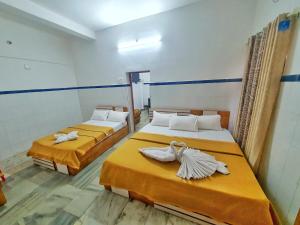 a room with two beds with towels on them at kollam Beach Resort in Kollam +9 photos