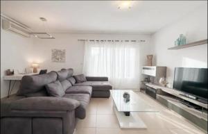 ein Wohnzimmer mit Sofa und Fernseher in der Unterkunft 3 Bed Villa Mar Menor Golf Heated Pool Terrace in Torre-Pacheco