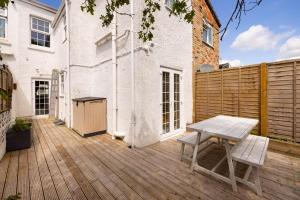 a wooden deck with a table and a bench on it at Charles Hope Salisbury Residence in Salisbury