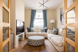 a living room with a couch and a tv at Charles Hope Salisbury Residence in Salisbury