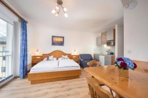 a bedroom with a bed and a table and a kitchen at MIA Appartements - non-serviced Appartements in Obertauern