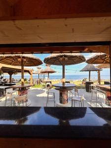 a view of a beach with tables and umbrellas at Hotel & Restaurant San Pellegrino in Folelli