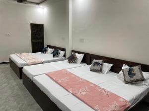 2 letti posti in una stanza con di Nakshatra palace a Ayodhya