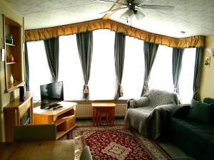 a living room with a couch and a tv at 8 Berth Central heated Golden Palm (Aspen GP) in Chapel Saint Leonards