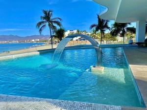 a swimming pool with a water fountain in a resort at Rooftop Pool Suites Vallarta in Bucerías