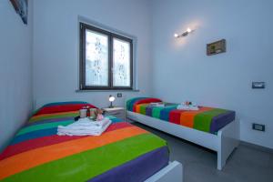 a bedroom with two beds with rainbow at Villa Laura Private Pool and Garden - Happy Rentals in Besozzo